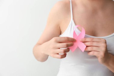 Açık renkli, tatlı pembe kurdele tutan kadın. Meme kanseri bilinçlendirme kavramı