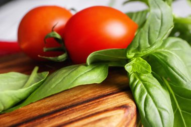 Taze fesleğen yaprakları ve domates gemide, portre