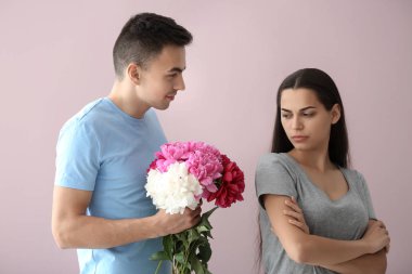 Rahatsız genç kadın sevgilisi renk arka plan üzerinde çiçek almak reddediyor