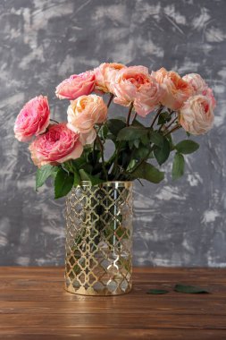 Vazo ile gri dokulu arka plan karşı masada güzel gül buketi