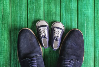 Ahşap arka plan üzerinde büyük ve küçük ayakkabılar. Babalar günü kutlama