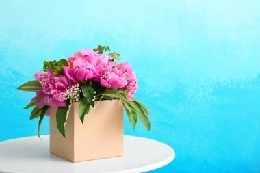 Renk arka plan karşı masada güzel şakayık çiçekli kutu