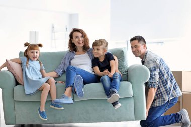 Yeni evde kanepe ailesiyle birlikte taşımak çalışan adam