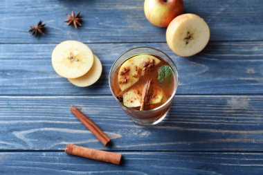 Lezzetli apple içki ve renk ahşap zemin üzerine tarçın ile cam