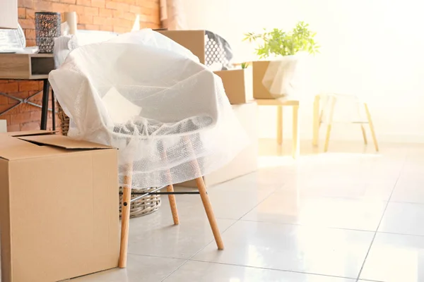 Interior items and packed carton boxes in room. Moving house concept