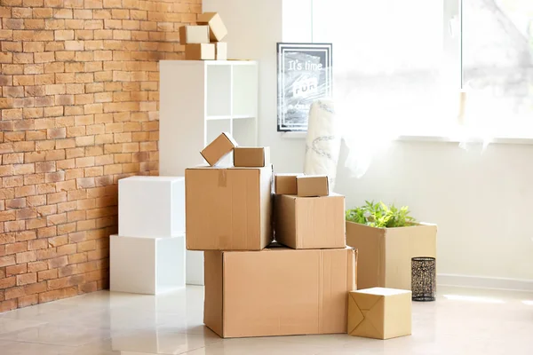 Carton boxes and interior items in room. Moving house concept