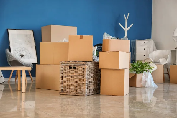 Carton boxes and interior items on floor in room. Moving house concept