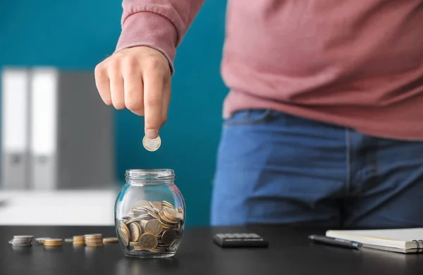 Man Lägga Mynt Glasburken Bordet Besparingar Koncept — Stockfoto