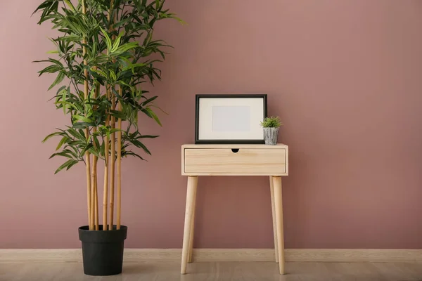 Meja Kayu Dengan Bingkai Dan Tanaman Hijau Dekat Dinding Warna — Stok Foto