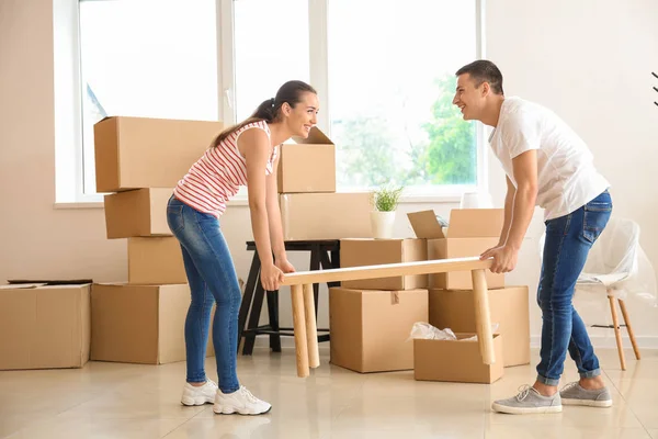 Young Couple Carrying Table Room Moving New Home — Stock Photo, Image