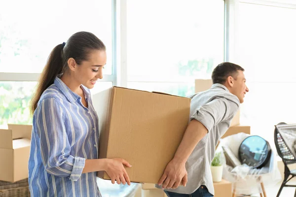 Young Couple Carrying Box Indoors Moving New House — Stock Photo, Image