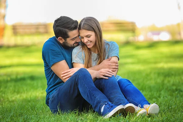 Park Yeşil Çim Üzerinde Oturan Mutlu Genç Çift — Stok fotoğraf