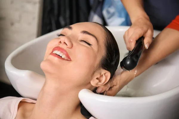 Young woman during washing of hair in beauty salon