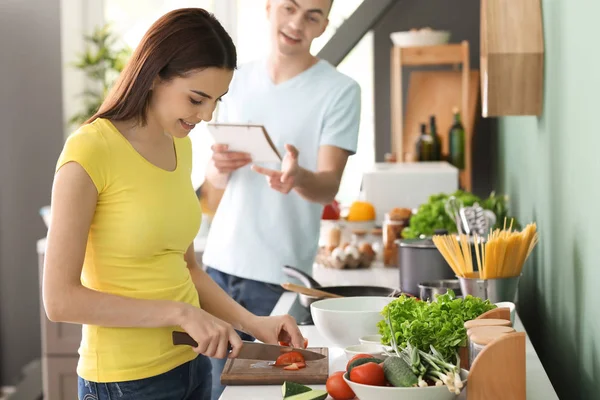 Jovem Cozinhando Enquanto Seu Marido Lendo Livro Receitas Cozinha — Fotografia de Stock