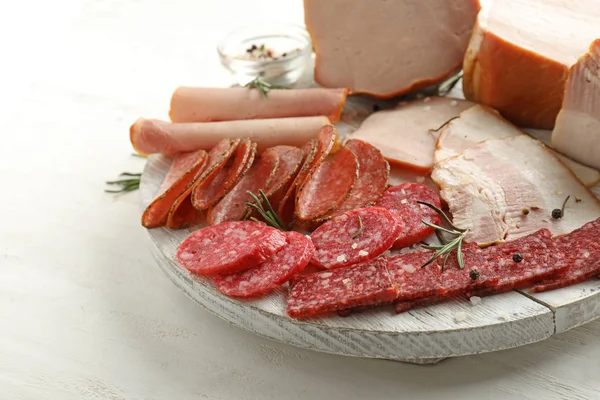 Assortment of delicious deli meats on wooden board