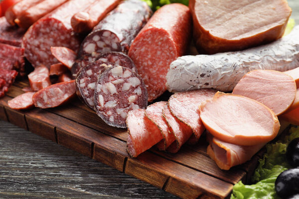 Ассортимент вкусных деликатесов на деревянной доске
