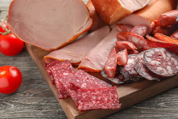 Assortment of delicious deli meats on wooden board