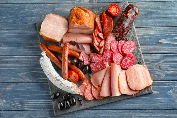 Variety of delicious deli meats on slate plate