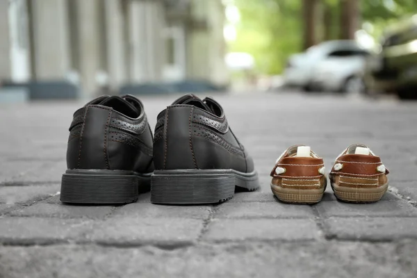 Big and small shoes on pavement outdoors. Father\'s day