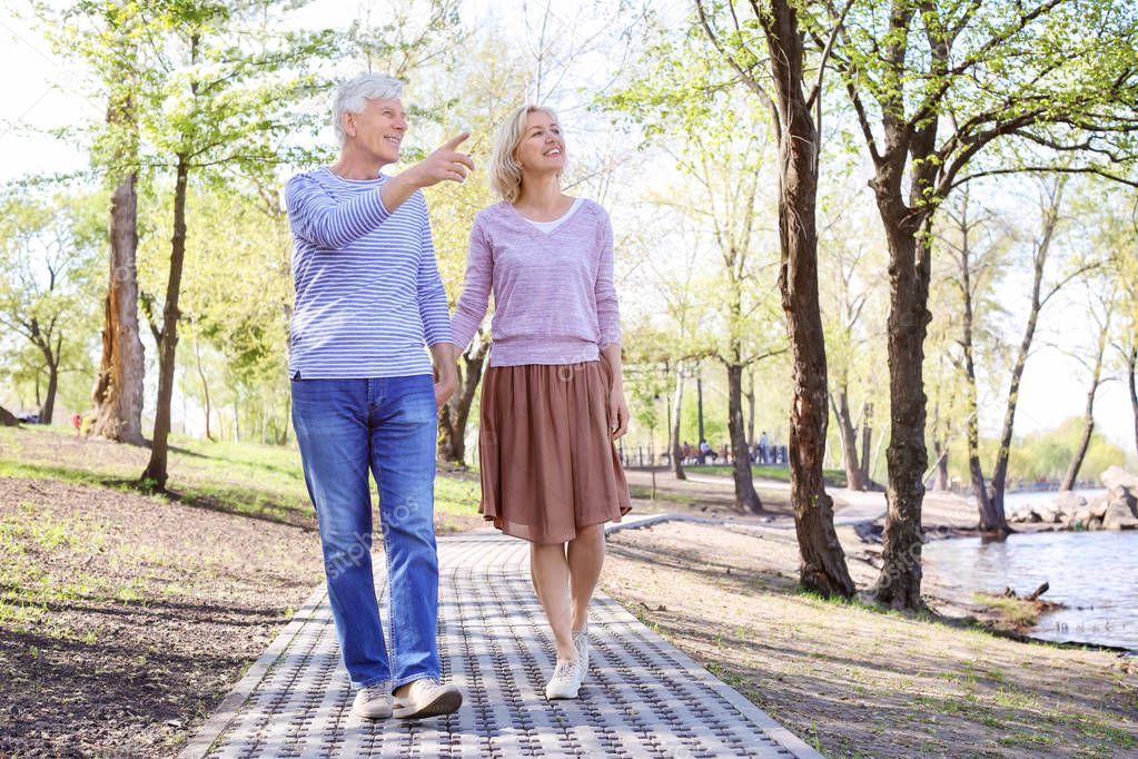 Mature couple walking in park on spring day