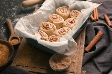 Mutfak masasının üstünde pişmemiş tarçın ile pişirme çanağı rulo
