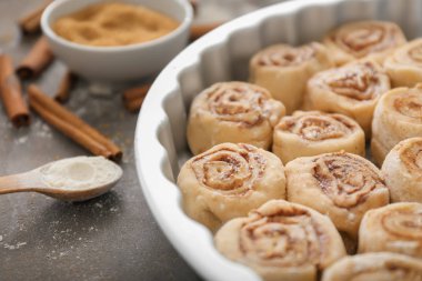 Pişmemiş tarçın ile pişirme çanağı mutfak masasında, portre rulo