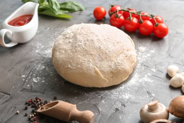 Çiğ hamur ve malzemeler için pizza üzerinde gri dokulu arka plan kompozisyonu