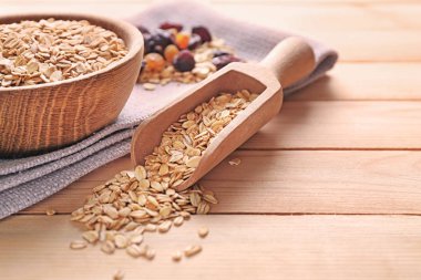 Kase ve kepçe ile ahşap arka plan üzerinde çiğ yulaf ezmesi