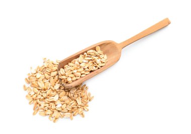 Kepçe ve beyaz arka plan üzerinde çiğ yulaf ezmesi yığını