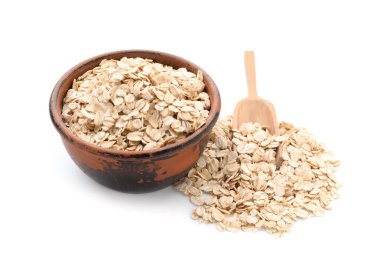 Beyaz arka planda çiğ yulaf ezmesi ile kase ve kepçe