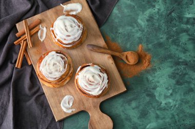 Yeşil zemin üzerine lezzetli tarçınlı çörek ile kompozisyon