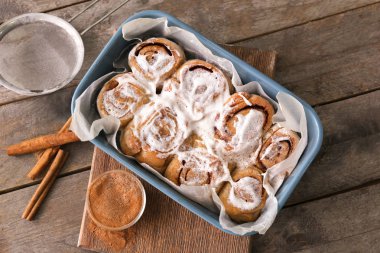 Ahşap arka plan üzerinde lezzetli tarçınlı çörek ile kompozisyon