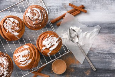 Ahşap arka plan üzerinde lezzetli tarçınlı çörek ile kompozisyon