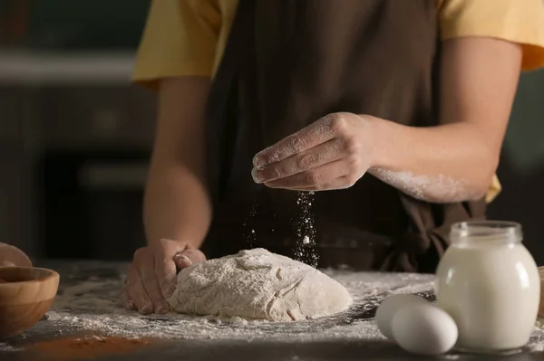 台所のテーブルの上に小麦粉と生地を振りかける女性 — ストック写真
