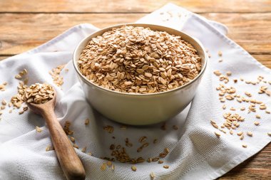 Kase ve çiğ yulaf gevreği ahşap masa üzerinde kaşıkla