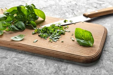 Ahşap tahta gri dokulu arka plan üzerinde taze yeşil fesleğen ile