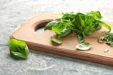 Ahşap tahta gri dokulu arka plan üzerinde taze yeşil fesleğen ile