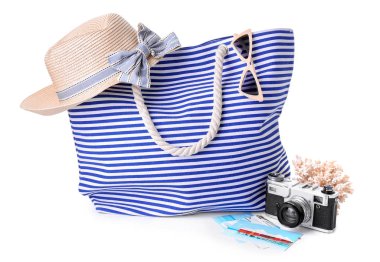 Beyaz arka planda aksesuarları olan plaj çantası.