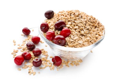 Çiğ yulaf ezmesi ve beyaz arka plan üzerinde taze kiraz ile kase