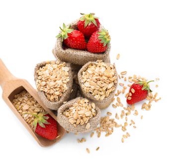 Çiğ yulaf ezmesi ve taze çilek beyaz zemin üzerine çuval ile kompozisyon