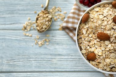 Çiğ yulaf ezmesi ve ahşap zemin üzerine fındık ile kase