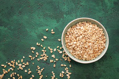 Arka plan rengi üzerinde çiğ yulaf ezmesi ile kase dokulu