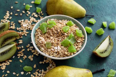 Kase çiğ yulaf ezmesi ile taze ve şekerlenmiş meyve renk dokulu arka plan üzerinde