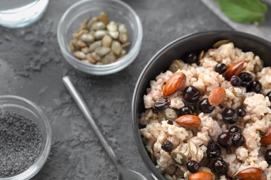 Lezzetli yulaf ezmesi, meyve ve fındık gri dokulu arka plan ile kase