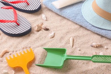 Plaj aksesuarları ve deniz kabukları kum üzerinde