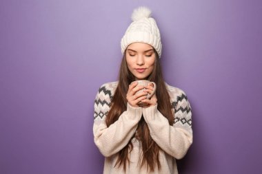 Fincan çay renk arka plan üzerinde tutarak sıcak giysiler güzel genç kadın