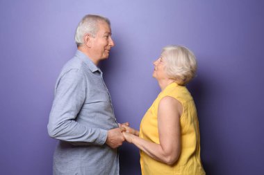 Renkli arka planda mutlu yaşlı çift