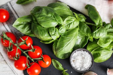 Taze fesleğen ve domates masada arduvaz levha