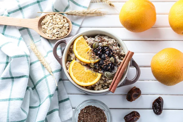 stock image Tureen with tasty oatmeal on white wooden background