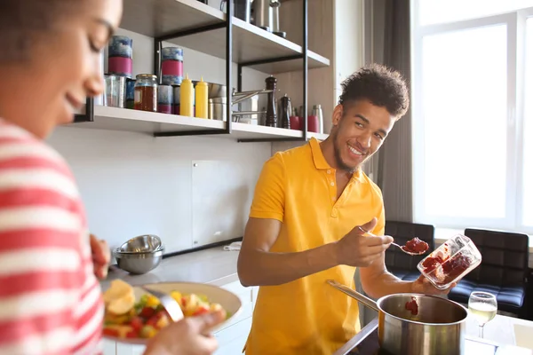 年轻的非裔美国人夫妇一起在厨房里吃饭和做饭 — 图库照片